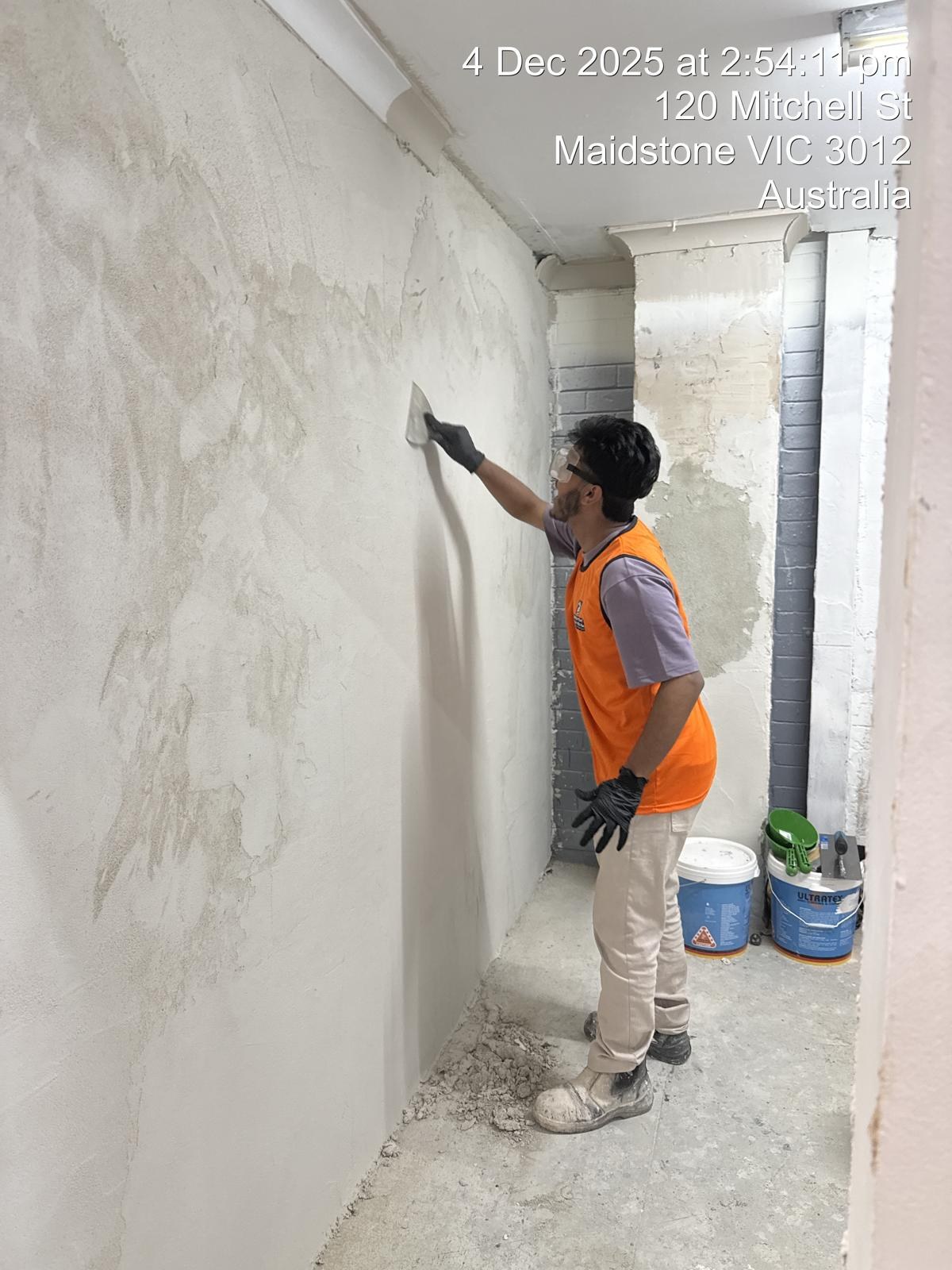 Naimul Islam Manna smoothing plaster on an interior wall